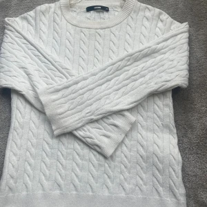 Vit kabelstickad tröja från BikBok - Supermysig vit kabelstickad tröja från BikBok i storlek XS. Tröjan har rund halsringning, långa ärmar och ribbade muddar. Perfekt för lager-på-lager och chill höst- och vinterstil.