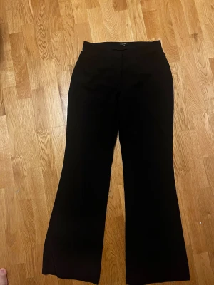 Svarta bootcut kostymbyxor Vero Moda - Svarta kostymbyxor från Vero Moda i storlek 40. Byxorna har bootcut-modell med utsvängda ben och medelhög midja. Köpta för 450kr men säljer för 100kr!🩷 Byxorna har en pytteliten liten defekt(se bild) men inget som märks! Skriv privat för fler bilder eller om du har frågor🩷