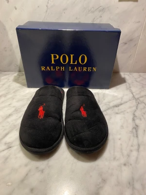 Ralph Lauren tofflor - Ett par as feta Ralph Lauren tofflor som har en snygg rutig design! Box kommer med och storleken är 41! Tofflorna passar allt från 39-43. Nypris är ca 800 kr! Kom Dm vid minsta fråga eller fundering!