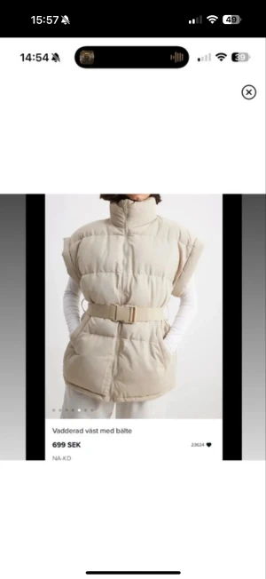 Beige dunväst med bälte från NA-KD - Stilren beige dunväst från NA-KD med hög krage, quiltad design och matchande bälte i midjan. Västen har dragkedja framtill och en loose passform som ger en cool och avslappnad look. Perfekt att slänga över en hoodie eller stickad tröja. Strl är xs/s