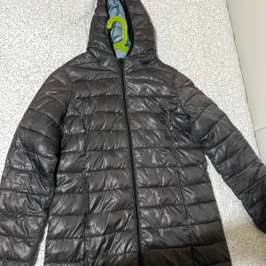 jacka med huva - Säljer en jacka med huva och dragkedja framtill. Jackan har quiltad design Perfekt för kyliga dagar. Passar både M och L