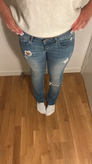 Blå lågmidjade jeans med slitningar från Hollister🤍 - Snyggaste lågmidjade jeansen från hollister med slitningar och hål. Verkligen en favorit!! Passar perfekt till vardags. Midjemått: 40cm innebenslängd:  74cm. Skriv vid några funderingar 🫶🏻