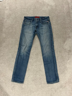 Replay  jeans blå 30/32 - Snygga Replay jeans i klassisk blå tvätt med lätt slitna detaljer. Jeansen är tillverkade i slitstarkt bomullsmaterial och har normal passform.