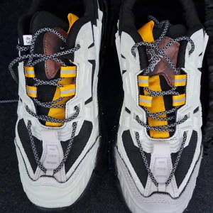 Chunky sneakers med gula detaljer - Riktigt feta chunky sneakers med svart mesh, vita och ljusrosa paneler samt coola gula detaljer. Snygga snören i svartvitt mönster och grov svart sula med vita stänk. Perfekt för dig som vill sticka ut med en modern streetstyle. helt nya skor