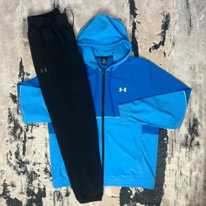UNDER ARMOUR - STORM WINDBREAKER TRACKSUIT - Under Armour – Storm Windbreaker Tracksuit • Jacka och byxa i olika färger • Storlekar från XS till 2XL • Går också få den på sneaks,se