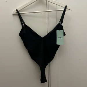 Svart body med djup rygg  - Säljer denna helt nya bodyn med djup rygg då jag har för många ❤️ den är i supertunt material och är väldigt stretchig och skön då den kommer från ett finare märke hos shein. Den har avtagbara band och vid köp får man med ett par genomskinliga. Ge prisförslag ❤️ obs kolla in min sida, säljer fler bodys! 