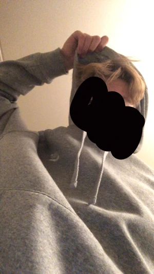Grå Nike hoodie med huva och snörning - Grå hoodie från Nike med klassisk logga på bröstet. Tröjan har huva med snörning och en stor magficka framtill. Långärmad och i mjukt bomullsmaterial, perfekt för chill eller häng med kompisar. Enkel och stilren design som funkar till jeans eller joggers.