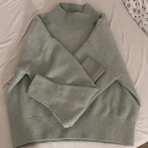 Ljusgrön polotröja från & Other Stories - Supermysig ljusgrön polotröja från & Other Stories, Los Angeles Atelier. Tröjan har ribbade muddar vid hals, ärmslut och nederkant, samt en hög krage som ger extra stilpoäng. Perfekt för lager-på-lager och chill dagar.