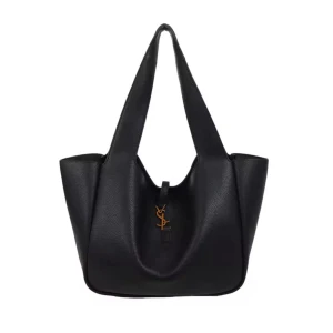 Svart axelväska från Yves Saint Laurent - Stilren svart axelväska från Yves Saint Laurent i mjukt skinn med klassisk YSL-logga i guld framtill. Väskan har breda axelremmar och rymlig form, perfekt för att bära med sig allt man behöver. Snygg och tidlös design som lyfter varje outfit.