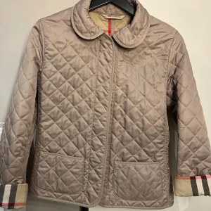 Burberry jacka  - Intressekoll på min Burberry jacka. Inga defekter och helt äkta. Finns fler bilder men kunde inte använda alla. Finns tillhörande skärp