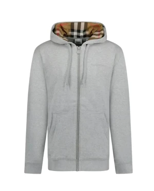 Burberry hoodie med rutigt foder - Säljer en snygg hoodie från Burberry med dragkedja och huva. Finns i både ljusgrå och svart. Insidan av huvan har det klassiska Burberry-rutiga fodret. Tröjan har snörning vid huvan, fickor fram och är långärmad. Perfekt för dig som vill ha en stilren look med lyxig touch.