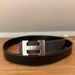 Bälte - Snyggt svart skärp  i silverfärgad metall. Perfekt accessoar för att lyfta din outfit med en lyxig touch.