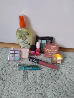 Sminkpaket - Säljer ett sminkpaket med två ZMILE ögonskuggspaletter i pastell och metallic, DDONNA 24K Diamonds ögonskuggspalett med gröna och neutrala toner, W7 Honolulu Sun-Blazed bronzer, W7 Glow highlighter, två eyeliners i grönt och turkos, samt ett matt flytande läppstift/blush i nude-rosa. Allt är öppnat men knappt använt. Säljs även separat, isåfall 20 kr st för det på bild två, 10 kr st för bild tre och 5 kr st för bild fyra. Säljer billigt för att jag vill bli av de de