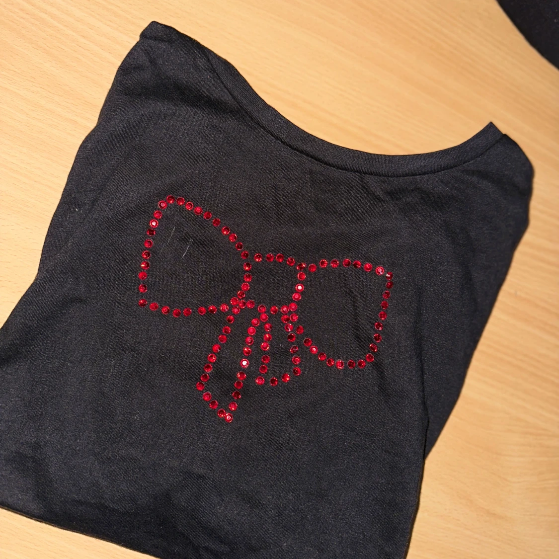 Svart topp med röd rosett i paljetter - 1