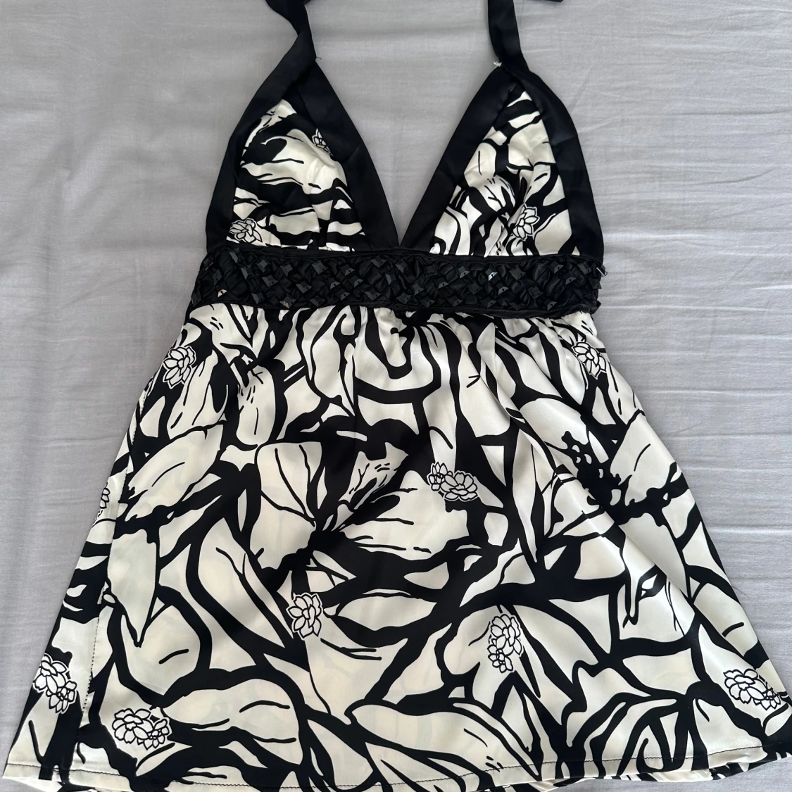 Svartvit halter top med blommönster och paljetter 