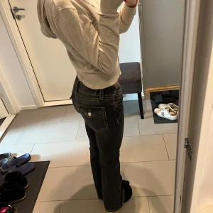 Lågmidjade jeans - Säljer dessa mörkgråa/svarta lågmidjade bootcut jeans från ginatricot. Köpta på 14+ avdelningen i storlek 152. Passar mig perfekt som vanligtvis har storlek 32, xs. Fina knappar på fickorna baktill.  Skick 10/10, sparsamt använda.  Nypris: 399kr 