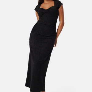 Svart glittrig långklänning Bubbleroom - Supersnygg helt oanvänd klänning med lappen kvar från Bubbleroom, med glittrigt material och en söt rosettdetalj vid bysten. Perfekt för dig som vill sticka ut med stil och glitter.🖤