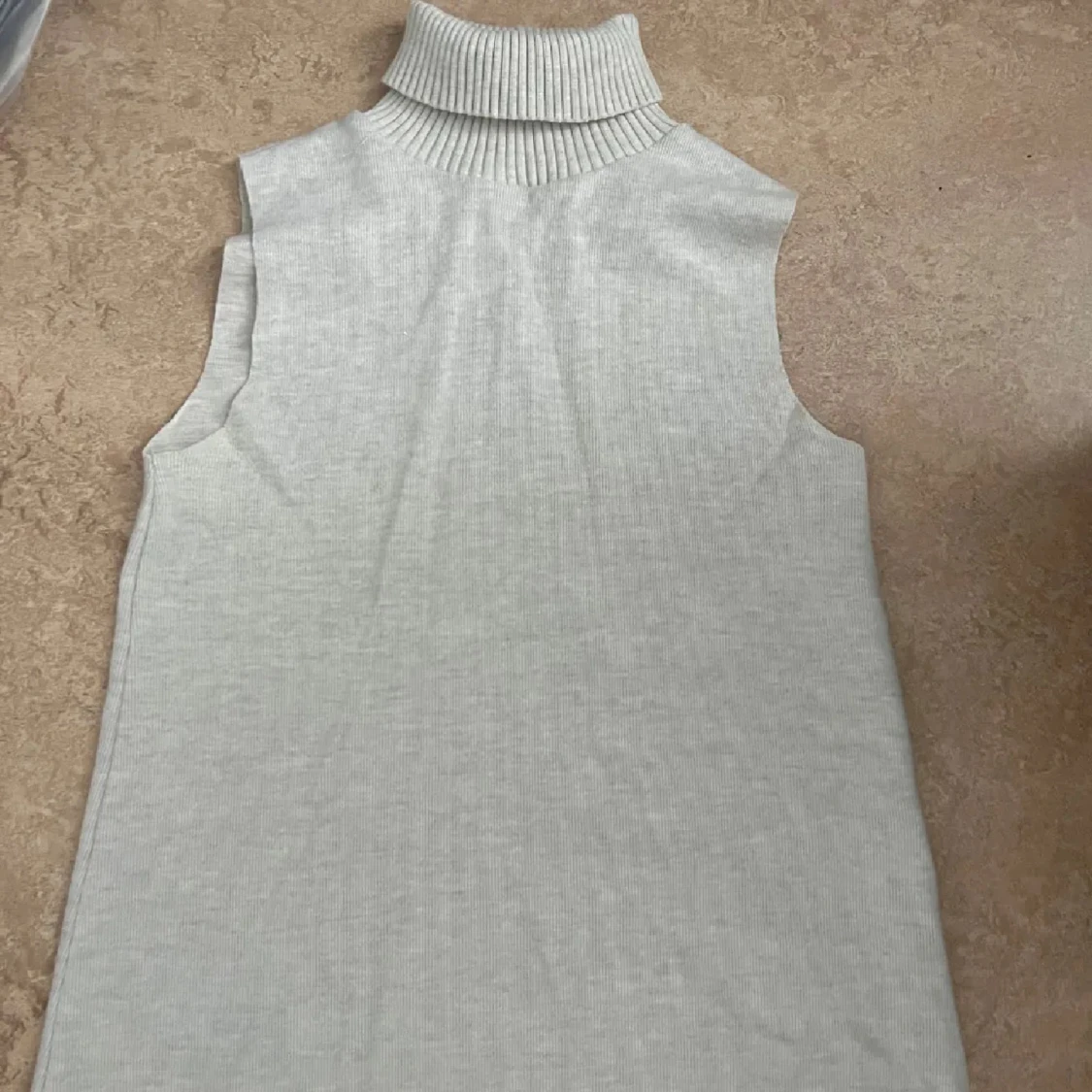 Ljusgrå ärmlös polotopp