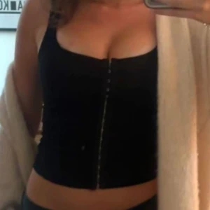 Svart croppad korsett, mjuk. - Säljer en svart croppad korsett som är mjuk och stretchig. Köpt för 299 kr