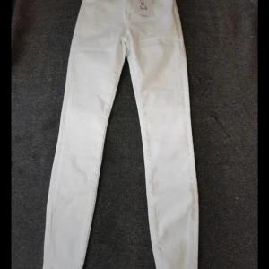 Vita high waist jeans från Jucad - Snygga vita jeans från Jucad i modellen JP Peachy High White A. Byxorna har hög midja och smal passform, perfekta till sneakers eller boots. Klassisk femficksdesign och tillverkade i bomull med stretch för extra komfort.