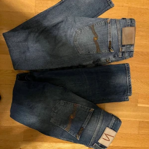 2X bundle - Två par klassiska blå jeans från Nudie Jeans med deras ikoniska broderade bakfickor och läderpatch i midjan. Jeansen har rak passform och är tillverkade i slitstarkt bomullsdenim. Perfekta för dig som gillar en tidlös och stilren look.