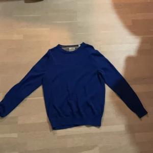 Blå bomullströja från Esprit - Snygg blå tröja från Esprit i extra fin bomull. Klassisk rund halsringning med ribbade muddar vid ärmslut och nederkant. Perfekt för dig som gillar stilrena och enkla plagg med en fräsch färg. Passar till både jeans och chinos.