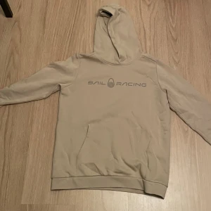 Beige hoodie från Sail Racing - Beige Sail Racing hoodie so har använts sparsamt och är i ett mycket bra skicka. Inga hål eller liknande och är storleken 160