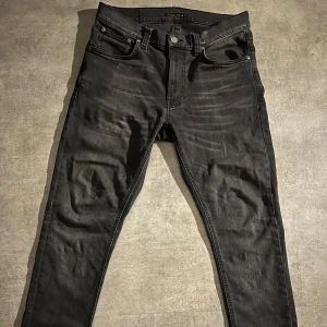 Nudie Jeans Lean Dean Mono Grey - Säljer ett par svarta Lean Dean jeans från Nudie Jeans i färgen Mono Grey. Jeansen är tillverkade av 99% ekologisk bomull och 1% elastan för en bekväm stretch. De har klassisk femficksdesign, smal passform och raka ben. Perfekta för en clean och stilren look.