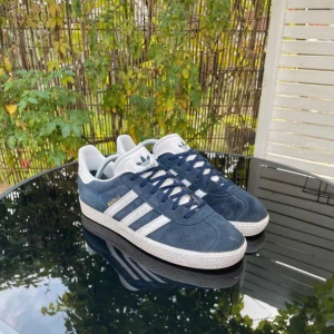 Adidas Gazelle Mörkblå - Extremt bra skick, knappt tecken på använd. Strl 38,5 men passar mer som 39-40. Hör av er vid funderingar!!