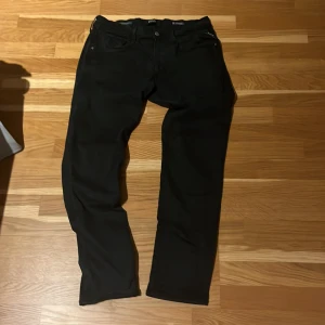 Replay Anbass Hyperflex svarta jeans - Svarta Replay Anbass Hyperflex jeans i storlek 33. Slimmad passform med klassisk femficksdesign och stretchigt material. Hör av er vid frågor 