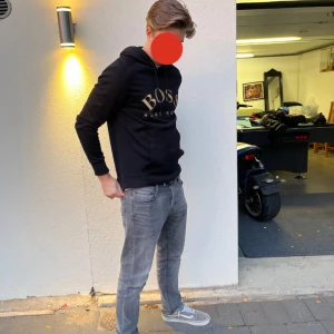 Svart Hugo Boss hoodie  - Säljer denna Hugo Boss hoodie med stilrentext. Skön passform som varken är för tajt eller för lös. Storleken är S MEN passar även för folk med M då materialet inte är stenhårt.