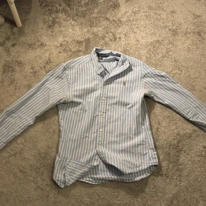Blåvit randig skjorta från Ralph Lauren - Tja säljer denna feta skjortan från Ralph lauren, köpt i sommras men e nu för liten 