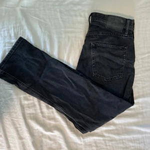 Jack & Jones Loose Chris svarta jeans - Säljer ett par svarta jeans från Jack & Jones, modellen Loose Chris. Jeansen har en loose passform och raka ben, klassisk femficksdesign och knappgylf. Materialet är slitstarkt denim i bomull och färgen är mörkt svart med lätt tvättad look.