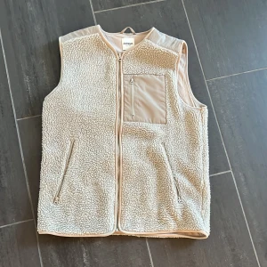 Beige fleeceväst från Dobber - Säljer en beige fleeceväst från Dobber i storlek small. Västen har en mjuk teddystruktur, hel dragkedja framtill och två sidofickor med dragkedja. På bröstet finns en ficka också med dragkedja. Perfekt till vardags men också afterskin🤩🎿Västen är köpt för 499kr på MQ herravdelning men passar även perfekt till tjejer. 