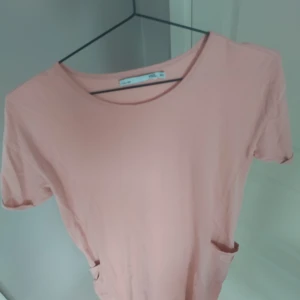 Ljusrosa t-shirtklänning från 157 - Säljer en enkel och chill ljusrosa t-shirtklänning från 157. Klänningen har rund hals, korta ärmar och två praktiska fickor framtill. Perfekt för dig som gillar en avslappnad och clean stil. Materialet är mjuk bomull som känns skönt mot huden.