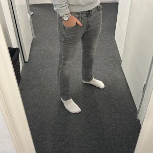 Gråa Replay jeans  - Säljer ett par grå skinny jeans med klassisk femficksdesign och smal passform. Jeansen har en snygg tvättad look och sitter tajt längs benen. Perfekta för dig som gillar en modern och stilren vibe. Sitter väldigt skönt