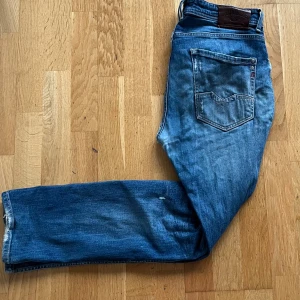 Replay anbass jeans - Replay anbass jeans i storlek W33 L30. Skick 6/10 med några slitningar och en defekt som finns med på bild 2 (syns ej vid användning och lätt att fixa). Passar mer som W32