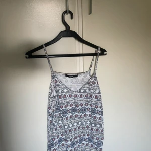 Mönstrad linnetopp från Bik Bok - Säljer en snygg linnetopp från Bik Bok med tunna axelband och v-ringning. Toppen har ett detaljerat mönster i blått, rött och vitt och är gjord i mjuk bomull. Perfekt för dig som gillar boho-vibe och vill ha något luftigt och fräscht!!