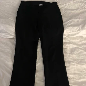 Svarta kostymbyxor med bootcut - Svarta kostymbyxor med raka ben från nelly. Byxorna har hällor för bälte och diskreta fickor framtill. 💘