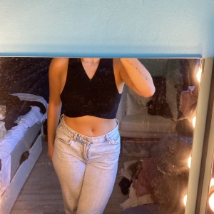 Svart croppad ribbad topp Bik Bok - Säljer en svart croppad ribbad topp från Bik Bok. Toppen är ärmlös med v-ringning och har en tight passform. Material=  stretchigt och bekvämt.