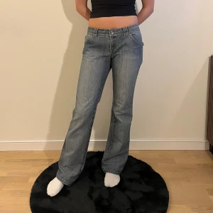 Blå bootcut jeans från Teddy's Core - Snygga blå jeans från Teddy's Core med bootcut passform och låg midja. Klassisk femficksdesign med coola ficklock bak och dragkedja fram. Modellen är 171 cm lång.