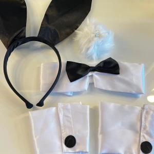 Playgirl Bunny set  - Playgirl Bunny set, perfekt för halloween! Snyggt diadem med stora svarta kaninöron. Setet inkluderar även vit fluffig svans, vit krage med svart fluga och matchande manschetter. Svart tyllkjol tillkommer. Aldrig använt