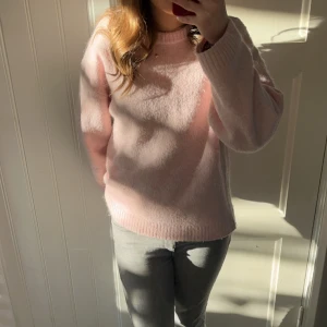 Ljusrosa stickad tröja Gina Tricot - Supermysig ljusrosa stickad tröja från Gina Tricot. Tröjan har en relaxed fit med rund halsringning och ribbade muddar vid ärmslut och nederkant. Perfekt för lager-på-lager under kyliga dagar.