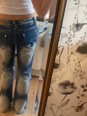 Blå bootcut jeans från You Vipin - Säljer ett par blå bootcut jeans från You Vipin med tydlig blekning och slitningar på framsidan. Jeansen har låg midja, klassiska fem fickor och silverfärgade nitar. Materialet är jeans. Skriv för frågor❤️❤️
