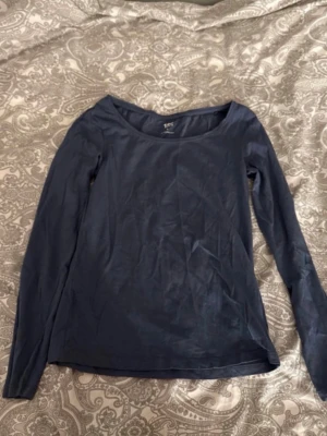 Mörkblå långärmad topp från 157 - En enkel och stilren mörkblå långärmad topp från 157. Tillverkad i mjuk bomull med lite stretch för extra komfort. Rund halsringning och rak passform gör den lätt att matcha till olika outfits.