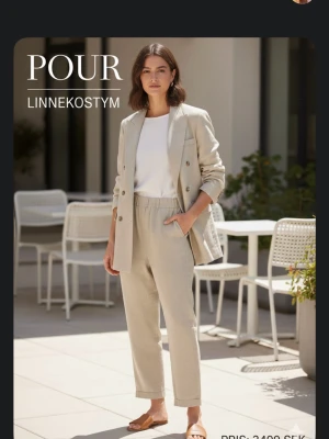 Beige linnkostym från Pour - Snygg och stilren beige linnkostym från Pour. Kavajen har dubbelknäppning, klassisk krage och fickor framtill. Byxorna har resår i midjan och raka ben. Perfekt för en fräsch och avslappnad look under varmare dagar.