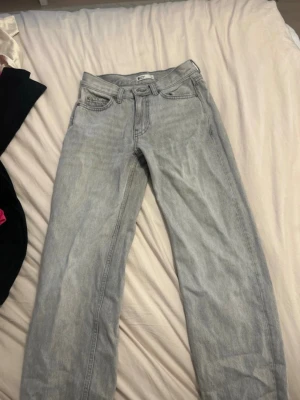 Gråa raka jeans från Gina - Säljer ett par gråa raka jeans från Gina tricot. Jeansen har en straight passform och är tillverkade i slitstarkt denimtyg. Perfekta för en avslappnad och trendig look.