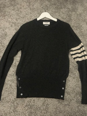 Mörkgrå tröja från Thom Browne - Säljer en mörkgrå långärmad tröja från Thom Browne. 100 procent kashmir, självklart äkta och jag har galjen man fick med också. Nypris runt 14 000
