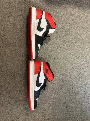 Nike Air Jordan 1 High röd/svart/vit - Säljer ett par Nike Air Jordans från THAILAND som är helt nya (inte använt alls) Det är storlek 42 men står 44! Det är bra kvalitet! Vid snabb affär = bättre pris! 
