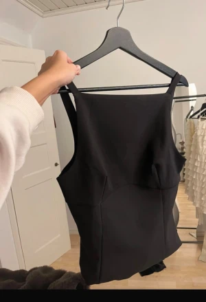 Svart topp - Svart topp från Zara, superfin! Har rosetter i ryggen